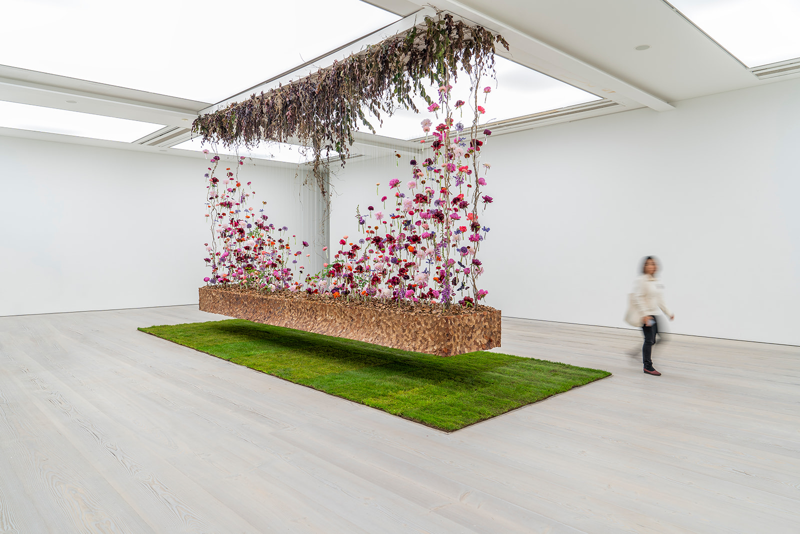 A suspended floral installation by Tom De Houwer in a bright gallery space
