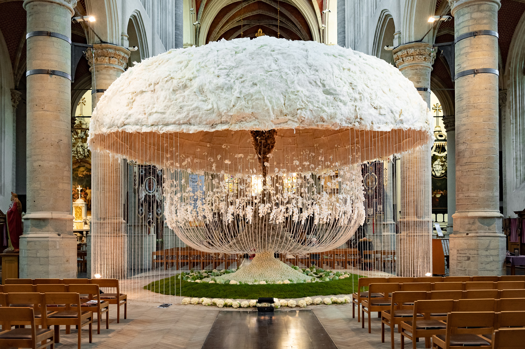 A monumental suspended floral installation by Tom De Houwer inside a historic hall
